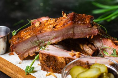 Ahşap bir tahtada ızgara domuz pirzolası ve sos.