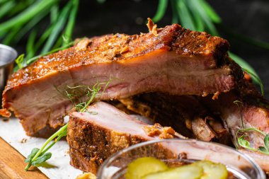 Ahşap bir tahtada ızgara domuz pirzolası ve sos.