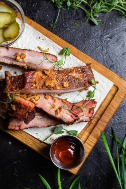 Ahşap bir tahtada ızgara domuz pirzolası ve sos.