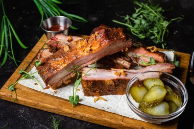 Ahşap bir tahtada ızgara domuz pirzolası ve sos.