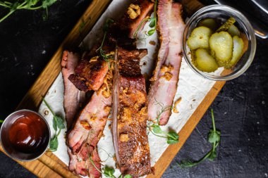 Ahşap bir tahtada ızgara domuz pirzolası ve sos.