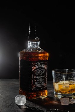 Karanlık bir arka planda bir şişe viski.