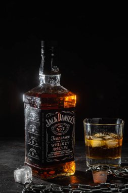 Karanlık bir arka planda bir şişe viski.