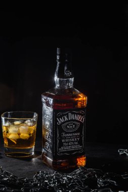 Karanlık bir arka planda bir şişe viski.