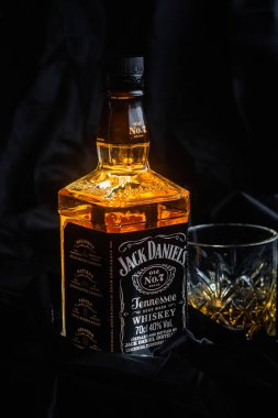Karanlık bir arka planda bir şişe viski.