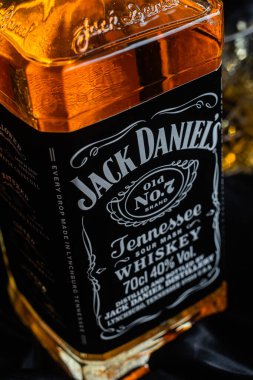 Karanlık bir arka planda bir şişe viski.