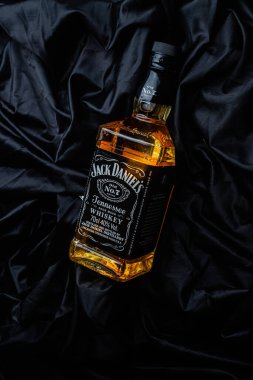 Karanlık bir arka planda bir şişe viski.