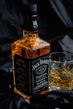 Karanlık bir arka planda bir şişe viski.
