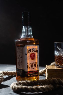 Karanlık bir arka planda bir şişe viski Jim Beam. Burbon