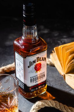 Karanlık bir arka planda bir şişe viski Jim Beam. Burbon
