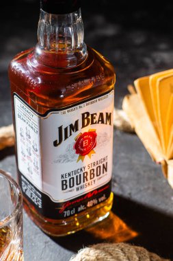 Karanlık bir arka planda bir şişe viski Jim Beam. Burbon