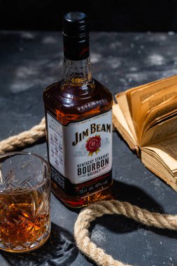 Karanlık bir arka planda bir şişe viski Jim Beam. Burbon