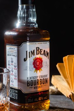 Karanlık bir arka planda bir şişe viski Jim Beam. Burbon
