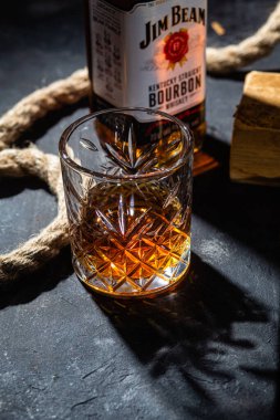 Karanlık bir arka planda bir şişe viski Jim Beam. Burbon