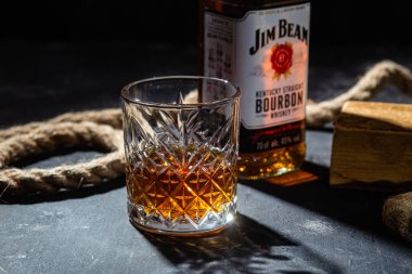 Karanlık bir arka planda bir şişe viski Jim Beam. Burbon