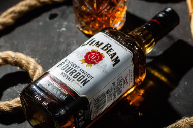 Karanlık bir arka planda bir şişe viski Jim Beam. Burbon