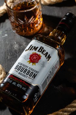 Karanlık bir arka planda bir şişe viski Jim Beam. Burbon