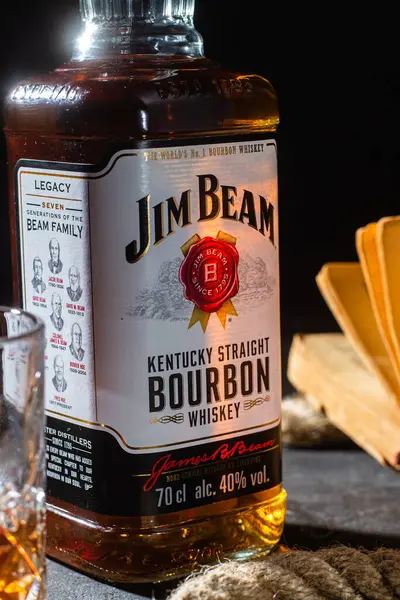 Karanlık bir arka planda bir şişe viski Jim Beam. Burbon