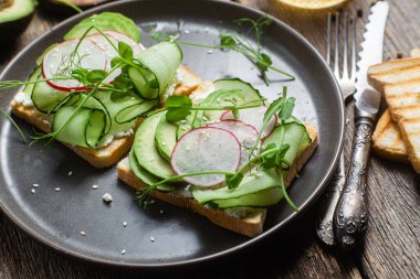 Krem peynirli beyaz ekmek tostu, avokado, salatalık ve turp.