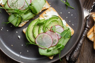 Krem peynirli beyaz ekmek tostu, avokado, salatalık ve turp.