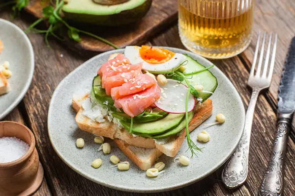 Krem peynirli tost, somon, yumurta, avokado, tabakta salatalık.