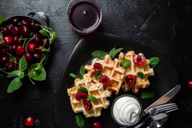 Viyana waffleları ve arka planda kirazlar. Belçika Waffle 'ları