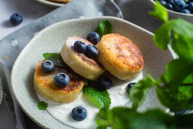 Krem soslu ve yabanmersinli süzme peynirli krep. syrniki 