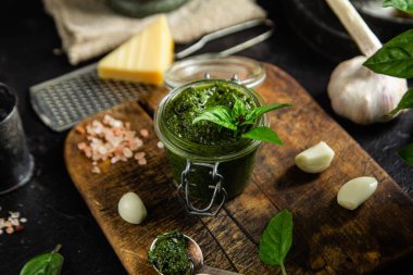 Masadaki cam kavanozda yeşil fesleğen sosu