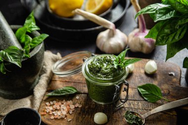 Masadaki cam kavanozda yeşil fesleğen sosu