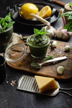 Masadaki cam kavanozda yeşil fesleğen sosu