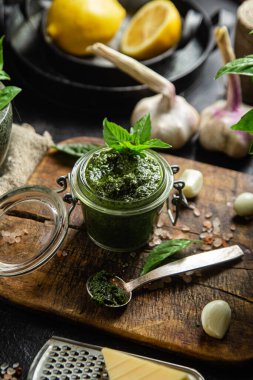 Masadaki cam kavanozda yeşil fesleğen sosu