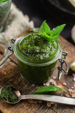 Masadaki cam kavanozda yeşil fesleğen sosu