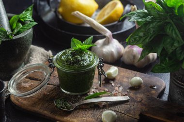 Masadaki cam kavanozda yeşil fesleğen sosu