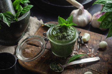 Masadaki cam kavanozda yeşil fesleğen sosu