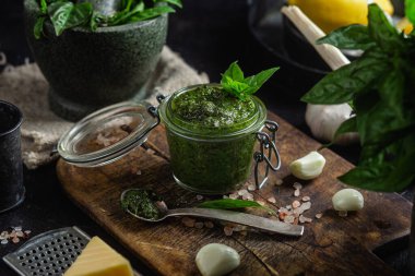 Masadaki cam kavanozda yeşil fesleğen sosu