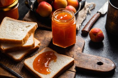 Masadaki cam kavanozda olgun kayısı reçeli.