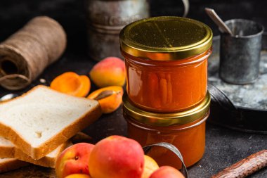 Masadaki cam kavanozda olgun kayısı reçeli.