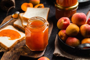 Masadaki cam kavanozda olgun kayısı reçeli.