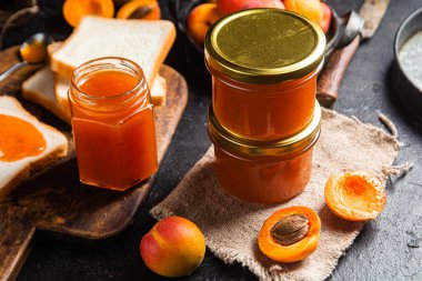 Masadaki cam kavanozda olgun kayısı reçeli.