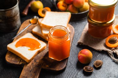 Masadaki cam kavanozda olgun kayısı reçeli.