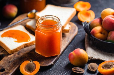 Masadaki cam kavanozda olgun kayısı reçeli.