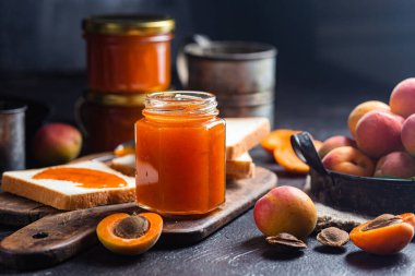 Masadaki cam kavanozda olgun kayısı reçeli.