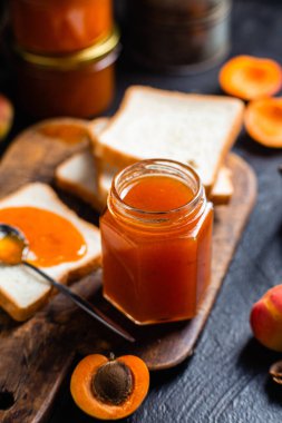 Masadaki cam kavanozda olgun kayısı reçeli.