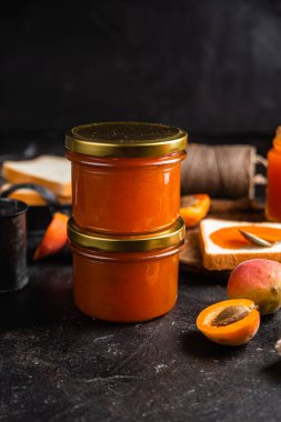 Masadaki cam kavanozda olgun kayısı reçeli.