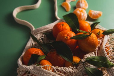 Clementine mandalinaları yeşil yapraklarla kaplıdır.