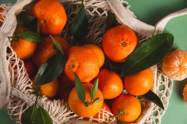 Clementine mandalinaları yeşil yapraklarla kaplıdır.