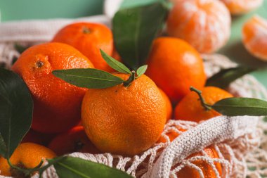 Clementine mandalinaları yeşil yapraklarla kaplıdır.