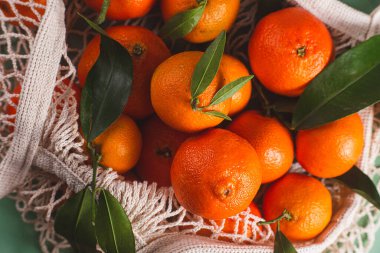 Clementine mandalinaları yeşil yapraklarla kaplıdır.