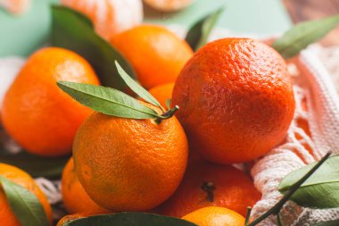 Clementine mandalinaları yeşil yapraklarla kaplıdır.