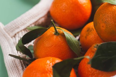 Clementine mandalinaları yeşil yapraklarla kaplıdır.